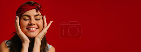 Photo for Close-up portrait of happy young hipster woman with colorful make-up touching face on red background - Royalty Free Image