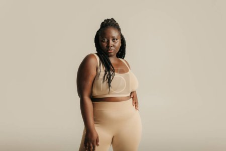Téléchargez les photos : Belle africaine plus taille femme en sous-vêtements regardant confiant dans son corps sur fond de studio - en image libre de droit