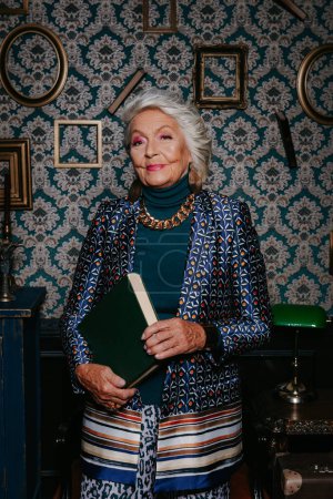 Téléchargez les photos : Elégante femme âgée dans le luxe porter rayonnant de confiance et de richesse tout en se tenant debout à la maison de style rétro - en image libre de droit