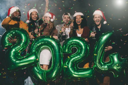 Téléchargez les photos : Joyeux jeunes amis tenant flûtes avec champagne tout en célébrant 2024 Nouvel An en boîte de nuit ensemble - en image libre de droit