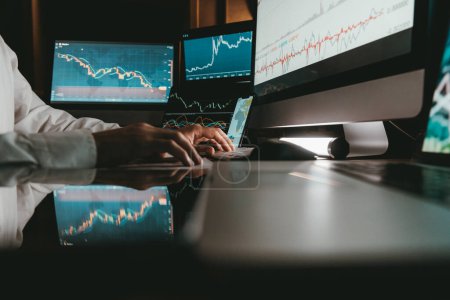 Photo for Close-up of male trader typing on computer keyboard while trading on stock market in night office - Royalty Free Image