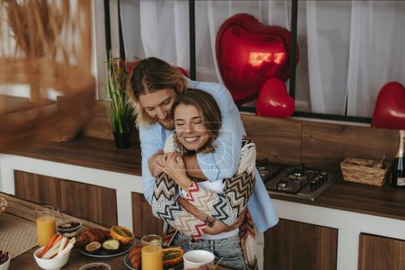 Foto de Vista superior de la joven pareja romántica abrazando mientras celebran el día de San Valentín en la cocina doméstica juntos - Imagen libre de derechos