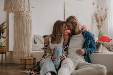 Téléchargez les photos : Jeune couple romantique embrassant face à face tout en célébrant la Saint-Valentin à la maison confortable décorée - en image libre de droit