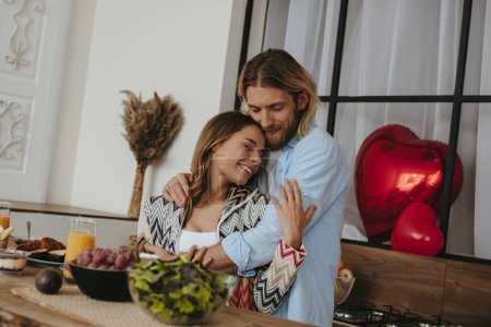 Téléchargez les photos : Jeune couple romantique embrassant tout en célébrant la Saint-Valentin à la cuisine domestique ensemble - en image libre de droit