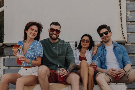 Foto de Grupo de amigos felices disfrutando de cócteles mientras se relajan al aire libre juntos - Imagen libre de derechos