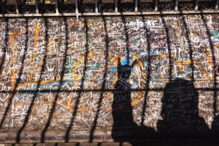 Photo for Cologne, Germany - February 25, 2015: Shadow of a man showing rock sign and the bars of Cologne Cathedral tower's top level over wall full of writings and grafitti. - Royalty Free Image