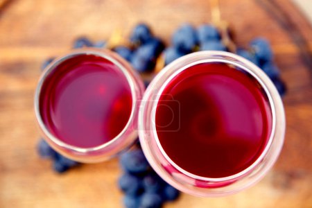 Foto de Vasos con vino tinto y un ramo de uvas. Composición con vino tinto en copas y racimo de uvas. vista lateral, vista superior. - Imagen libre de derechos