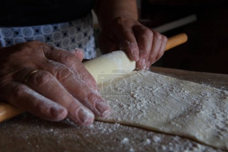 Foto de La fabricación de un dulce tradicional de Chipre, la mujer rorring masa con alfiler - Imagen libre de derechos