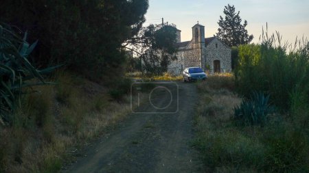 Téléchargez les photos : Voiture garée sur la route, avec monastère de la Grèce antique en arrière-plan - en image libre de droit