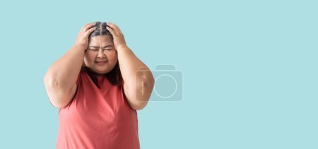 Foto de Asian fat woman, Fat girl , Chubby, overweight unhappy measuring her,  isolated on blue background - Imagen libre de derechos