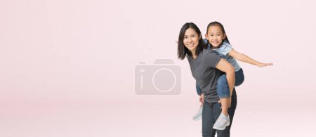 Téléchargez les photos : Happy asian family of mother and daughter hug spread out your arms, isolated on pink background with Clipping paths for design work empty free space - en image libre de droit