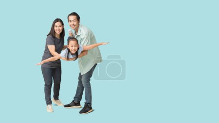Foto de Happy asian family of father, mother and daughter hug spread out your arms, isolated on blue background with Clipping paths for design work empty free space - Imagen libre de derechos