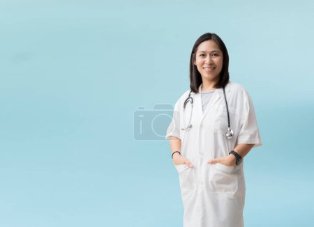 Téléchargez les photos : Asian female doctor posing and smiling, isolated on blue background with Clipping paths for design work empty free space - en image libre de droit