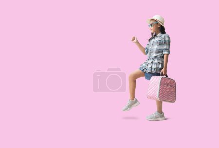 Foto de Pretty asian little girl and hat relaxing  summer vacation travel concept. Smiling cute little girl isolated on pink background with Clipping paths for design work empty free space - Imagen libre de derechos