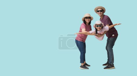 Photo pour Happy asian family vacation, Father, mother and child spread out your arms holiday travel concept, isolated on blue background. Clipping paths for design work empty free space - image libre de droit