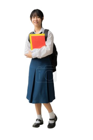 Foto de Feliz niña estudiante asiática sonriente con uniforme sosteniendo libros y mochila, fondo aislado, recorte de caminos para el trabajo de diseño - Imagen libre de derechos