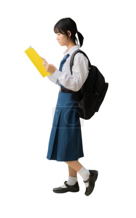 Téléchargez les photos : Heureuse étudiante asiatique souriante portant uniforme tenant des livres et un sac à dos, fond isolé, sentiers de coupe pour le travail de conception - en image libre de droit