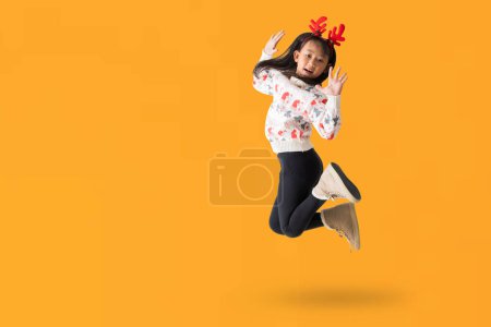 Téléchargez les photos : Joyeux jeune fille asiatique portant un pull de Noël avec des cornes de rennes, Happy souriant danse saut portrait complet du corps, isolé sur fond blanc, Clipping Chemins pour le travail de conception - en image libre de droit