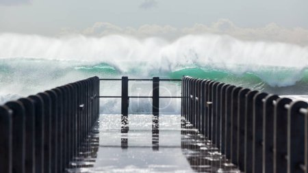 Foto de Ola de agua de energía oceánica explotando frente al muelle de la playa embarcadero
. . - Imagen libre de derechos