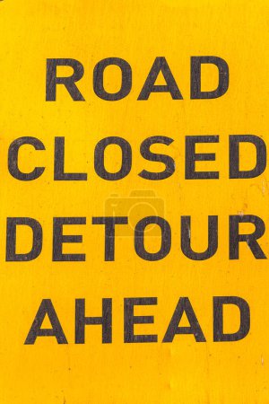 Photo for Road construction warning sign words Road Closed Detour Ahead. Close-Up Yellow and Black detail. - Royalty Free Image