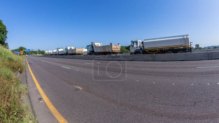 Photo for Construction road highway expansion improvements industrial trucks between concrete barriers a roadside countryside perspective. - Royalty Free Image