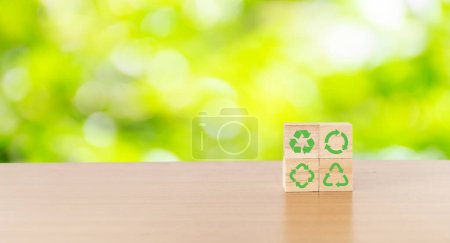 Das Konzept von Nachhaltigkeit oder Umweltschutz. Holzwürfel mit Nachhaltigkeit, Umwelt, grüner Wirtschaft, erneuerbaren Energien, Recycling-Ikone mit Naturhintergrund.