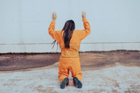Téléchargez les photos : Prisonnier en robe orange concept, Portrait de femme asiatique en uniformes de prison sur fond blanc, - en image libre de droit