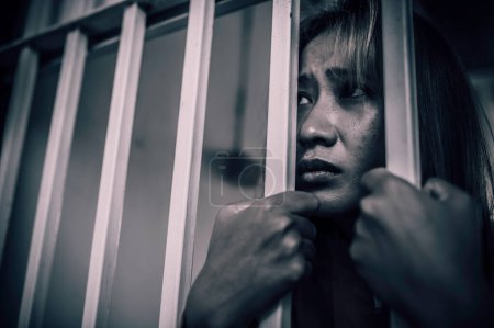 Foto de Retrato de mujeres desesperadas por atrapar la prisión de hierro, el concepto de prisionero, la gente de Tailandia, la esperanza de ser libres, si la violación de la ley sería arrestado y encarcelado. - Imagen libre de derechos