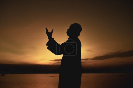Photo for Silhouette Young asian muslim man praying on sunset,Ramadan festival concept - Royalty Free Image