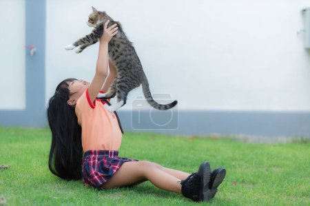 Téléchargez les photos : Portrait of cute asian little girl with her cat - en image libre de droit