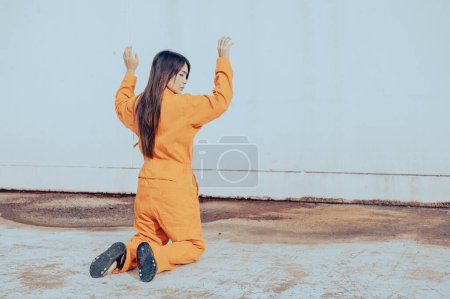Téléchargez les photos : Prisonnier en robe orange concept, Portrait de femme asiatique en uniformes de prison sur fond blanc, - en image libre de droit