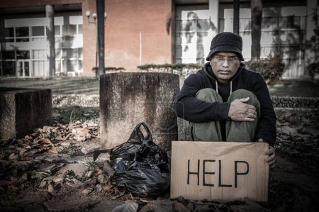 Foto de Hombre asiático está sin hogar en el camino lateral, un extraño tiene que vivir solo en el camino porque no tiene familia. - Imagen libre de derechos