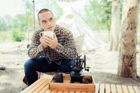 Photo pour Asian handsome man drink coffee,Male camping in the forest,Time for relax - image libre de droit