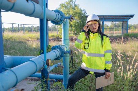 Foto de Ingenieros ambientales trabajan en plantas de tratamiento de aguas residuales, Técnico de fontanero femenino que trabaja en el suministro de agua - Imagen libre de derechos