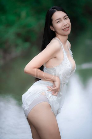 Photo for Portrait of sexy asian woman at the waterfall,Feeling fresh at the river,Thai female relax at country - Royalty Free Image