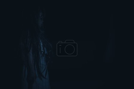 Foto de Sad child ghost at night,Halloween  Festival concept,Friday 13th,Horror movie scene,A girl with doll - Imagen libre de derechos