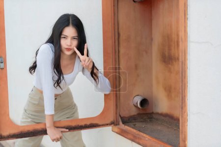 Foto de Retrato de chica hipster en el fondo de la pared de ladrillo, Hermosa pose de mujer asiática para tomar una foto, estilo Kawaii - Imagen libre de derechos