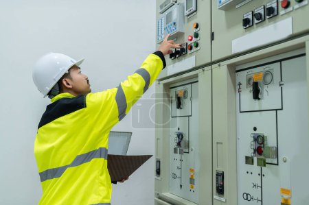 Téléchargez les photos : Ingénieur électricien vérifiant la tension au Cabinet de distribution d'énergie dans la salle de contrôle, entretien préventif Annuel, Thaïlande Électricien travaillant dans l'entreprise - en image libre de droit