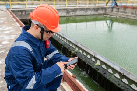 Foto de Water plant maintenance technicians, mechanical engineers check the control system at the water treatment plant. - Imagen libre de derechos