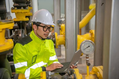 Photo for Asian engineer wearing glasses working in the boiler room,maintenance checking technical data of heating system equipment,Thailand people - Royalty Free Image