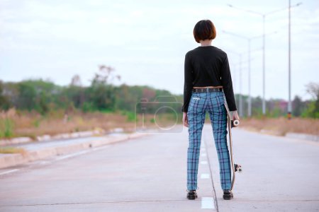 Téléchargez les photos : Asian woman play skateboard at the park,Punk girl style - en image libre de droit