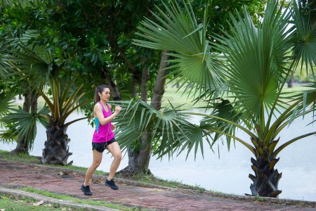 Téléchargez les photos : Asiatique belle femme courant dans le parc, Thaïlande gens, Les coureurs courent entraînement pour la compétition, Style de vie de la femme moderne - en image libre de droit