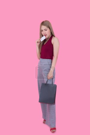 Photo for Beautiful asian woman with shopping bag and credit card in hand on pink background,Thailand people is using a credit card and enjoys shopping - Royalty Free Image