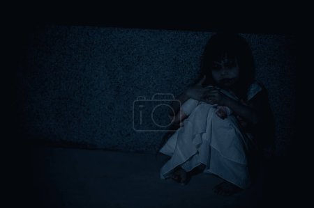 Téléchargez les photos : Sad child ghost at night,Halloween  Festival concept,Friday 13th,Horror movie scene,A girl with doll - en image libre de droit