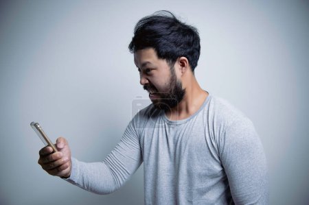Foto de Asiático guapo hombre enojado sobre fondo blanco, Retrato de joven Estrés concepto masculino, Mal humor después de hablar por teléfono - Imagen libre de derechos
