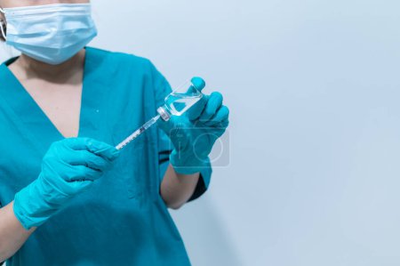 Foto de Médico asiático con jeringa y vacuna para proteger el virus covid-19 sobre fondo blanco - Imagen libre de derechos
