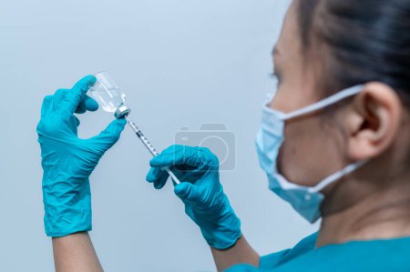Photo for Asian doctor with Syringe and vaccine for protect covid-19 virus on white background - Royalty Free Image