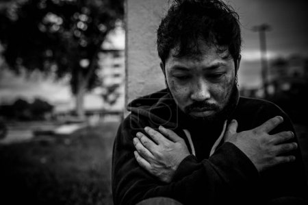 Téléchargez les photos : Asiatique homme est sans abri à la route de côté, Un étranger doit vivre sur la route seul parce qu'il n'a pas de famille. - en image libre de droit