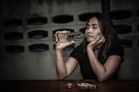 Foto de Asiática mujer beber vodka solo en casa en la noche, Tailandia personas, estrés mujer borracho concepto - Imagen libre de derechos