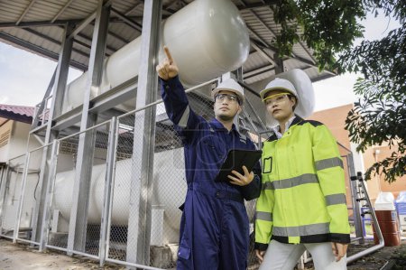Foto de Ingenieros trabajan en el lugar para mantener helio líquido, control del programa de mantenimiento preventivo, gente de Tailandia, técnicos e ingenieros discuten el trabajo juntos. - Imagen libre de derechos